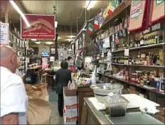  ?? Kevin Kirkland/Post-Gazette ?? Customers wait for muffuletta sandwiches at Central Grocery and Deli in New Orleans.