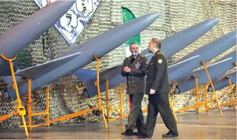  ?? (Iranian Army/WANA/Reuters) ?? IRAN’S ARMY chief Maj. Gen. Abdolrahim Mousavi and Defense Minister Brig. Gen. Mohammad-Reza Ashtiani walk near Iranian drones that are inducted into Iran’s Army, in Tehran, earlier this month.