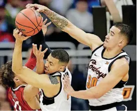  ?? [AP PHOTO] ?? Oklahoma State guards Jeffrey Carroll (30) and Kendall Smith fight for a rebound against Oklahoma guard Trae Young during the first half Wednesday in Kansas City, Mo.