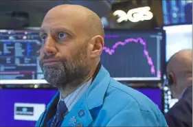  ?? Richard Drew/Associated Press ?? Specialist Meric Greenbaum works Friday on the floor of the New York Stock Exchange.