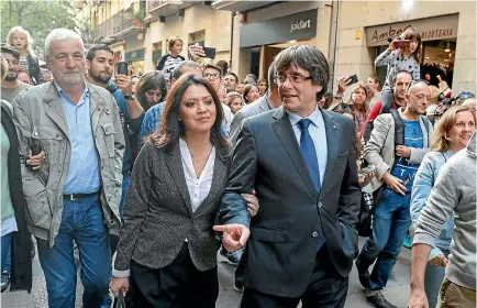  ?? PHOTO: REUTERS ?? Sacked Catalan President Carles Puigdemont strolls with his wife Marcela Topor during a walkabout in Girona the day after the Catalan regional parliament declared independen­ce from Spain.