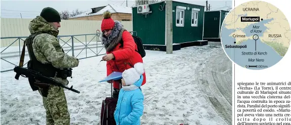  ??  ?? Confine Una guardia ucraina controlla i documenti di una donna che attraversa la frontiera di Milove con la figlia (Evgeniy Maloletka / Ap)