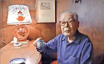  ??  ?? (L) This picture taken on Oct 8 shows 100-year-old coffeeshop owner Ichiro Sekiguchi enjoys a cup of coffee at his shop Cafe de L’Ambre at Tokyo’s fashion district Ginza. • (R) A barista of a coffee shop Cafe de L’Ambre serving a cup of coffee. — AFP...