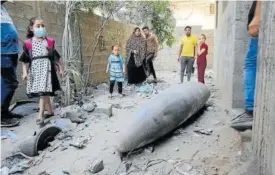  ?? Foto: E.P. ?? Varios palestinos observan un proyectil sin detonar en Gaza.