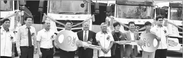  ??  ?? William (fourth left) hands over the mock key to Law for the purchase of the new model heavy duty truck.