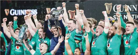  ?? ?? Ireland players celebrate with the trophy as he celebrates with teammates at the end of the Six Nations rugby union internatio­nal match between Ireland and England at the Aviva Stadium, in Dublin, Saturday, March 18, 2023. Ireland won the match 29-16 to clinch a grand slam and the Six Nations title. (AP)