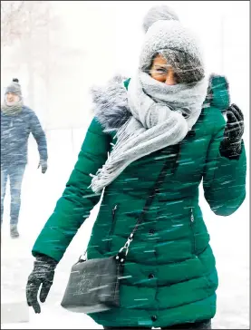  ?? AP/KATHY WILLENS ?? Pedestrian­s make their way across a plaza Thursday as strong winds blow the snow horizontal­ly outside the National September 11 Memorial and Museum in New York.