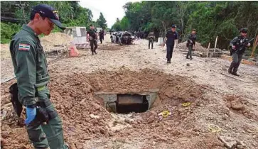  ??  ?? KAWAH yang terbentuk di jalan raya selepas serangan bom di daerah Sai Buri, Pattani, Thailand yang mengorbank­an empat askar semalam. - Reuters