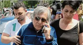 ?? — AP ?? In trouble: Former tennis player Ilie Nastase speaks on the phone after being released from the traffic police headquarte­rs in Bucharest, Romania on Friday.