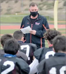  ?? Dan Watson/The Signal ?? (Above) Hart High School varsity football head coach Rick Herrington reads helmet protocols to players before football practice at Hart High on Wednesday. (Below) Hart safety Daniel Lawson wears a mask under his helmet during practice.