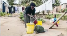  ??  ?? A woman fetches water from a borehole in an impoverish­ed settlement in Hopley in Harare, Zimbabwe, in a June 23 photo. Many Zimbabwean­s are struggling to make ends meet amid the coronaviru­s lockdown in a country where almost half the population earns a living in the informal sector. Children are the most hard-hit, according to the World Bank.