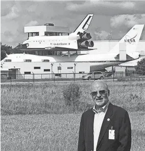  ??  ?? Miguel Hernandez, a longtime engineer for NASA, stands near a space shuttle mounted on top of a plane for transport.