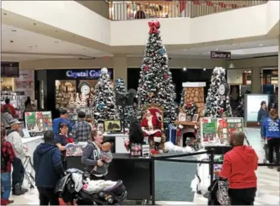  ?? NICHOLAS BUONANNO — NBUONANNO@TROYRECORD.COM ?? People wait in line to get a photo with Santa Claus at Crossgates Mall on Friday morning.