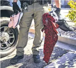  ?? ?? Garret McKenney, a deputy first class with the Bernalillo County Sheriff’s Office, goes through merchandis­e recovered in February 2023 after the arrest of a suspected shoplifter outside a Kohl’s store in Albuquerqu­e.