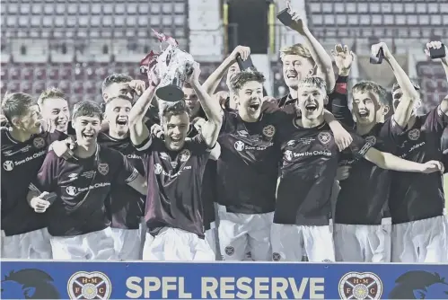  ??  ?? 0 The victorious Hearts players celebrate their triumph after defeating Motherwell 2-0 in the Reserve Cup final at Tynecastle last night.