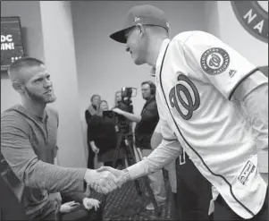  ?? The Associated Press ?? WELCOME TO WASHINGTON: Washington Nationals pitcher Stephen Strasburg, left, shakes hands with new teammate Patrick Corbin Friday during a news conference at Nationals Park in Washington.