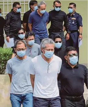  ?? PIC BY ASYRAF HAMZAH ?? The accused being led out of the Sessions Court in Kuala Lumpur yesterday.