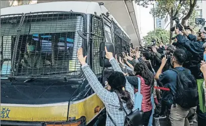  ?? ANTHONY KWAN / GETTY ?? Manifestan­tes prodemocra­cia protestan ante el furgón que se lleva a los tres activistas condenados