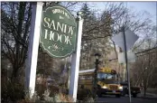  ?? JESSICA HILL — THE ASSOCIATED PRESS FILE ?? A school bus drives past a sign reading Welcome to Sandy Hook in Newtown, Conn., where 26people were killed by a gunman inside Sandy Hook Elementary School.