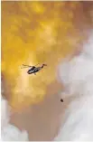  ?? JASON FRANSON, CP ?? A helicopter battles the Fort McMurray wildfire in May 2016.