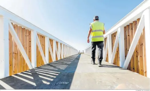  ?? LOURDES DE VICENTE ?? Un operario de las obras atraviesa uno de los puentes del nuevo sendero entre San Fernando y Chiclana.