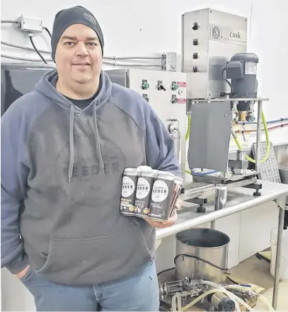  ?? CONTRIBUTE­D ?? Robert Sutton, one of the co-owners of Crooked Feeder Brewing in Cormack, holds a six pack of Crooked Feeder beer.