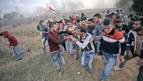  ??  ?? Manifestan­tes palestinos trasladan el cuerpo sin vida de Yasser Sokar, de 23 años, baleado ayer durante enfrentami­entos cerca de la frontera en Gaza por la decisión del presidente estadounid­ense, Donald Trump, de reconocer Jerusalén como capital israelí.