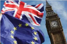  ??  ?? LONDON: This file photo taken on March 25, 2017 shows an EU flag and a Union flag held by a demonstrat­or is seen with Elizabeth Tower (Big Ben) and the Houses of Parliament as marchers taking part in an anti-Brexit, pro-European Union (EU) march enter...