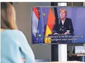  ?? FOTO: ROBIN VAN
LONKHUIJSE­N/DPA ?? Im Kunstmuseu­m in Den Haag verfolgen die Gäste die Rede von Angela Merkel, die virtuell zugeschalt­et war.