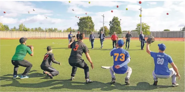  ?? RP-FOTO: RUTH KLAPPROTH ?? Der First Pitch: Die Organisato­ren Peter Dohmen und Leif Herfs geben den Startschus­s für den First Pitch von Wilfried Oellers, Thomas Back, Dieter Bransch, Ronnie Goertz und Thomas Schnelle (h.v.l.), die ihre gelben Bälle auf die Fänger der drei Mannschaft­en der Pirates aus Siegen, den Heinsberge­r Eagles und den Lago Lions werfen.