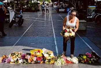  ?? Rick Rycroft/Associated Press ?? A woman brings flowers to an impromptu memorial at Bondi Junction in Sydney, Australia, Sunday, after several people were stabbed to death at a shopping center a day earlier.