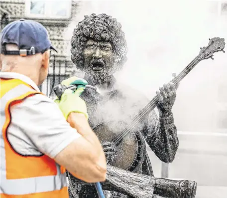  ?? PHOTO: MARK CONDREN ?? Man of the people: A worker cleans the statue of Luke Kelly on South King Street in Dublin.