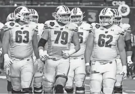  ?? ETHAN MILLER/GETTY IMAGES ?? Offensive linemen Tanor Bortolini (63) and Cormac Sampson (62) started for UW in the Las Vegas Bowl due to injuries.