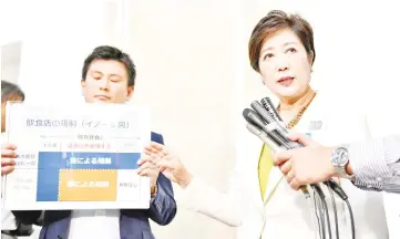  ??  ?? Koike (right) speaks to reporters during a press briefing after a session of the metropolit­an assembly in Tokyo. — AFP photo