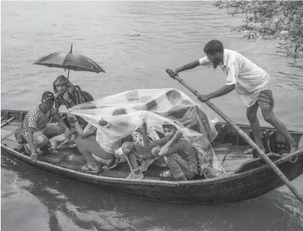  ?? ?? PESSOAS atravessam o rio Buriganga durante condições adversas causadas pelo ciclone Asani em Dhaka, Bangladesh.