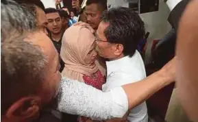  ?? PIC BY EDMUND SAMUNTING ?? Parti Warisan Sabah president Datuk Seri Mohd Shafie Apdal embracing his wife, Datin Seri Shuryani Shuaib, at the Kota Kinabalu Court Complex yesterday.