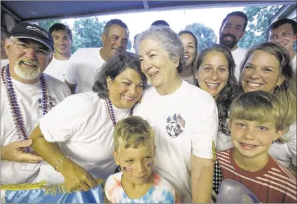  ?? BRANDON DILL/SPECIAL TO THE COMMERCIAL APPEAL ?? Ana Bran (center, right) gets a hug from her daughter, Rose McCahill, as she gathers in her garage with dozens of relatives for a family portrait before the group travels to watch the U.S. men’s soccer team take on Guatemala at Nissan Stadium in...