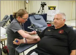  ?? The Sentinel-Record/Richard Rasmussen ?? DONATING: Arkansas Blood Institute phlebotomi­st Tina Bell, left, prepares to take blood from Hot Springs Fire Department Lt. Terry Fryhover during the annual Guns ‘n’ Hoses Blood Drive at First Baptist Church Tuesday.