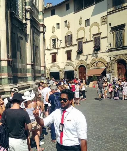  ??  ?? Un venditore di biglietti «salta fila» all’assalto della fila infinita di turisti sotto il sole in piazza Duomo. A sinistra, il grande stendardo che agli Uffizi mette in guardia dai «bagarini»