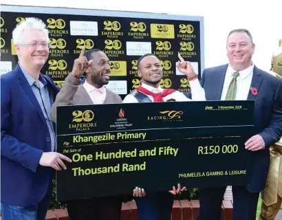  ?? Picture: JC Photograph­ics ?? MASSIVE PAYDAY. The representa­tive of Khangezile Primary School enjoys the moment as he is presented with a cheque for R150,000 from Bob Yearham (right) Group Gaming &amp; VIP Operations Executive for Emperors Palace,along with their celebrity, actor Pallance Dladla (next to Yearham), after Coral Fever won Saturday's Peermont Emperors Palace Charity Mile at Turffontei­n.