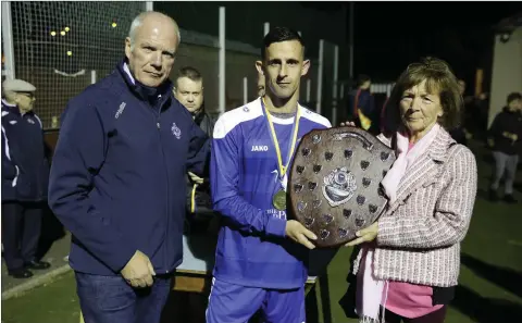  ??  ?? Michael Conlon, Chairman of the Wicklow League with Ashford captain Danny Byrne, who accepts the Tommy Heffernan Shield from the late Tommy’s wife Margaret.