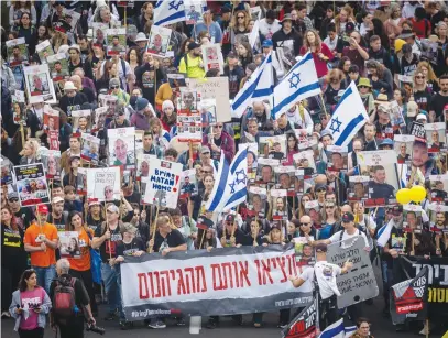  ?? (Yonatan Sindel/Flash90) ?? FAMILIES OF the hostages kidnapped by Hamas terrorists in Gaza and their supporters march to Jerusalem on Highway 1 in their protest yesterday. The banner at the bottom in red letters says: ‘Get them out of hell.’