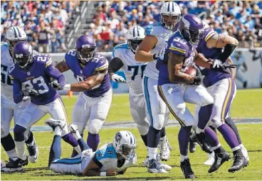  ??  ?? Minnesota defensive end Danielle Hunter (99) recovers a fumble by Tennessee quarterbac­k Marcus Mariota, on ground, and returns it 24 yards for a touchdown during the fourth quarter of Sunday’s game. The Vikings won 25-16.