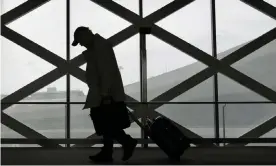  ??  ?? A man drags luggage while walking at San Francisco internatio­nal airport in California. Photograph: Jeff Chiu/AP