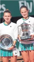  ?? AP ?? Latvia’s Jelena Ostapenko (right) holds the championsh­ip trophy after defeating Romania’s Simona Halep (left) in the women’s singles final of the French Open tennis tournament yesterday.