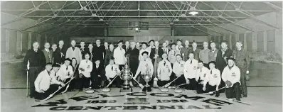  ?? COURTESY OF GUELPH CIVIC MUSEUMS ?? Below: A photograph of a curling team at Victoria Rink posing around the Sleeman Trophy, left, and the Guelph Tankard, right, 1938.