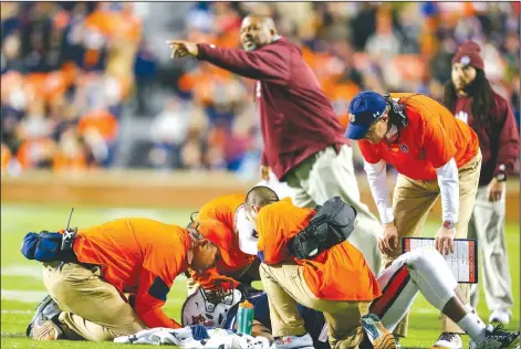  ?? File Photo/AP ?? Auburn head coach Gus Malzahn (right) looks on as trainers attend to linebacker Darrell Williams (bottom) while Alabama A&M head coach James Spady (center, back) reacts to a targeting call Nov. 19, 2016, during a college football game in Auburn, Ala.