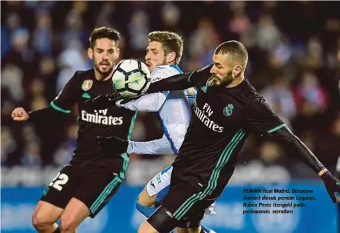 ??  ?? PEMAIN Real Madrid, Benzema (kanan) diasak pemain Leganes, Ruben Perez (tengah) pada perlawanan, semalam.