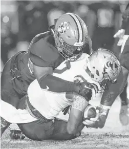  ?? REINHOLD MATAY/ORLANDO SENTINEL ?? Seminole’s Brendan Loy tackles Bishop Moore’s Jordan Jackson in an emotional 31-30 victory on Friday.