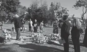  ?? ?? Chaplain Nicholas Jordan, left, holds up a bowl of incense during the Los Angeles County ceremony of the unclaimed dead.